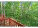 An elevated outdoor wood deck overlooking a lush green backyard with mature trees providing privacy at 4514 Creekwood Nw Cir, Kennesaw, GA 30152