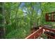 An elevated outdoor wood deck overlooking a lush green backyard with mature trees, lounge chairs, and a grill at 4514 Creekwood Nw Cir, Kennesaw, GA 30152