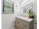 Bathroom featuring a vanity with cabinet storage, granite countertop, decorative plant, mirror, and updated light fixture at 4514 Creekwood Nw Cir, Kennesaw, GA 30152