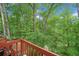 Wood deck with wooded, green backyard and patio seating at 4514 Creekwood Nw Cir, Kennesaw, GA 30152