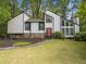 Striking home with modern architecture, multiple windows, a well-manicured lawn, and a stone accent wall at 4514 Creekwood Nw Cir, Kennesaw, GA 30152