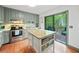 Bright kitchen features grey cabinets, stainless steel appliances, an island and sliding doors to a deck at 4514 Creekwood Nw Cir, Kennesaw, GA 30152