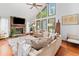 Inviting living room boasting a stone fireplace, gleaming hardwood floors, and large windows with captivating outdoor vistas at 4514 Creekwood Nw Cir, Kennesaw, GA 30152