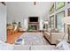 Sunlit living room featuring a stone fireplace, hardwood floors and expansive windows providing picturesque outdoor views at 4514 Creekwood Nw Cir, Kennesaw, GA 30152