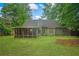 Green backyard with a home, screened porch, trees, and lawn at 1642 Ashmar Sw Ln, Marietta, GA 30064