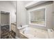 Relaxing bathroom with a garden tub and natural light from the window at 1642 Ashmar Sw Ln, Marietta, GA 30064