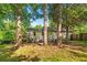 Back exterior view of this home surrounded by mature trees and a spacious backyard area at 1761 Flat Shoals Se Rd, Atlanta, GA 30316