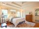 Bedroom with tray ceiling, hardwood floors, and windows, next to the bathroom at 1761 Flat Shoals Se Rd, Atlanta, GA 30316