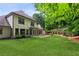 Beautiful backyard featuring a well-manicured lawn, patio, and lush landscaping with trees and flower beds at 2437 Camden Lake Nw Vw, Acworth, GA 30101