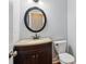 This is a modern bathroom with a granite countertop, a dark wooden vanity, a round mirror, and a toilet at 2437 Camden Lake Nw Vw, Acworth, GA 30101