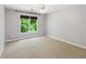 Bright bedroom featuring neutral paint, plush carpet, and a window with lush green views at 2437 Camden Lake Nw Vw, Acworth, GA 30101