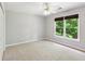 Bright bedroom featuring neutral paint, plush carpet, a ceiling fan, and a window with lush green views at 2437 Camden Lake Nw Vw, Acworth, GA 30101