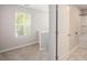 Bright upstairs hallway with a window and a bathroom with a white door and a shower at 458 Ajo Way, Dallas, GA 30157
