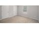Neutral bedroom with a window, two doors, and a carpeted floor at 458 Ajo Way, Dallas, GA 30157