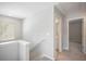 Upstairs hallway featuring a window, a staircase, and doors leading to various rooms at 458 Ajo Way, Dallas, GA 30157