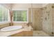 Spa bathroom featuring large window with tub and seamless glass shower at 2628 Hollow Pne, Conyers, GA 30094