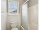 Cozy bathroom with toilet, window, and shower behind frosted glass at 3641 Willow Club Dr, Loganville, GA 30052