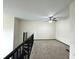 Spacious loft area with neutral carpet, ceiling fan, and railing overlooking the lower level at 390 17Th Nw St # 6001, Atlanta, GA 30363