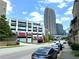 View of a city street with a parking deck, modern architecture, and a skyline backdrop at 390 17Th Nw St # 6001, Atlanta, GA 30363