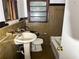 Bathroom with wall tile, pedestal sink, toilet, and tub with shower at 668 Lynn Sw Cir, Atlanta, GA 30311