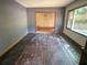 A spacious living room with hardwood floors and a window, needing restoration at 668 Lynn Sw Cir, Atlanta, GA 30311