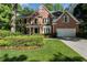 Beautiful two-story brick home featuring a well-manicured lawn and mature trees for added curb appeal at 1575 Wynridge Pointe, Alpharetta, GA 30005