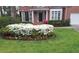 Charming brick home featuring a manicured lawn and garden bursting with blooming white azaleas in the front yard at 1575 Wynridge Pointe, Alpharetta, GA 30005
