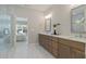 Bathroom featuring a double vanity, marble countertop, and glass-enclosed shower with tile surround and a view to bedroom at 2610 Lisa Sw Dr, Atlanta, GA 30311