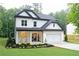 Charming two-story home featuring white siding, black trim, a covered porch, and a well-manicured front yard at 2610 Lisa Sw Dr, Atlanta, GA 30311