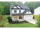 Charming two-story home featuring white siding, black trim, a covered porch, and a well-manicured front yard at 2610 Lisa Sw Dr, Atlanta, GA 30311