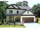 Charming two-story home features a manicured front yard, covered porch, and a two-car garage at 2610 Lisa Sw Dr, Atlanta, GA 30311