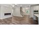 Modern open-concept living room with a fireplace, hardwood floors, and open stairs, creating a welcoming space at 2610 Lisa Sw Dr, Atlanta, GA 30311