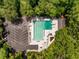 Aerial shot displays the pool area with ample lounge chairs, umbrellas, and a parking lot nestled among mature trees at 4774 Olde Village Ln, Atlanta, GA 30338
