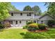 Backyard with a patio, lush lawn, mature trees, and white two-story home exterior at 4774 Olde Village Ln, Atlanta, GA 30338