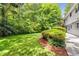 Expansive backyard with lush green lawn, mature trees, and well-maintained landscaping at 4774 Olde Village Ln, Atlanta, GA 30338