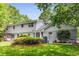 A lush backyard featuring a green lawn, mature trees, and the rear of the white two-story home at 4774 Olde Village Ln, Atlanta, GA 30338