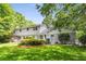 Spacious backyard featuring a well-manicured lawn, mature trees, and the home's exterior at 4774 Olde Village Ln, Atlanta, GA 30338