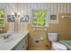 Cozy bathroom featuring a sink, toilet, and window for natural light at 4774 Olde Village Ln, Atlanta, GA 30338