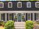 Charming two-story home with dormer windows, a gray brick facade, and manicured landscaping at 4774 Olde Village Ln, Atlanta, GA 30338