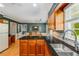 Well-lit kitchen with wood cabinets, stainless steel sink, granite countertops, and an adjacent dining area at 4774 Olde Village Ln, Atlanta, GA 30338