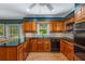 Spacious kitchen features granite countertops, wood cabinets, and black appliances, with a sunny dining area at 4774 Olde Village Ln, Atlanta, GA 30338