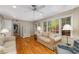Bright living room featuring hardwood floors, neutral paint, and a ceiling fan for added comfort at 4774 Olde Village Ln, Atlanta, GA 30338