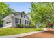 Charming home with grey painted brick, and an attached garage, surrounded by lush greenery at 4774 Olde Village Ln, Atlanta, GA 30338