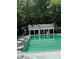 View of pool area, lifeguard chair, umbrellas, and a white pool house, all surrounded by mature trees at 4774 Olde Village Ln, Atlanta, GA 30338