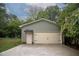 A two-car garage with an attached entrance door, surrounded by green trees and a lush green lawn at 599 Honey Creek Rd, Conyers, GA 30094
