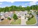 Aerial view of a charming neighborhood showcasing a beautiful two-story home with lush greenery at 6235 Crescent Landing Dr, Cumming, GA 30028