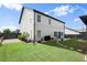 A well-maintained backyard features green grass, landscaping, and an outdoor patio area with string lights at 6235 Crescent Landing Dr, Cumming, GA 30028