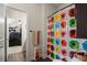 Bright bathroom featuring colorful shower curtain, decorative storage, and easy access from an adjacent office at 6235 Crescent Landing Dr, Cumming, GA 30028