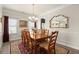 Formal dining room with a large wooden table, chandelier, and ample natural light from the windows at 6235 Crescent Landing Dr, Cumming, GA 30028