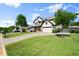 Elegant two-story home with a lush green lawn and mature trees lining the property at 6235 Crescent Landing Dr, Cumming, GA 30028
